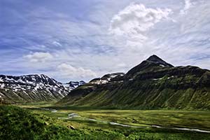 grüne Ebene vor Gebirgskette