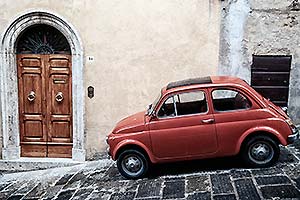 geparkter Fiat 500 auf abfallender Strasse