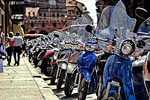 reihenweise geparkte Vespas am Strassenrand