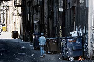Mann läuft durch dreckige Seitengasse