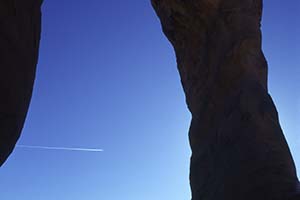 Flugzeug zieht Kondensstreifen durch Delicate Arch
